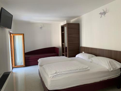 1 dormitorio con 1 cama blanca y 1 silla roja en Agriturismo Ca' Verde, en SantʼAmbrogio di Valpolicella