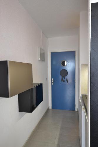 un couloir avec une porte bleue dans une chambre dans l'établissement Studio Naturiste SUMMER Port Nature 656, au Cap d'Agde