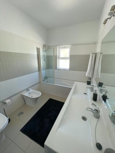 a bathroom with a tub and a sink and a toilet at LINHA D ÁGUA - ap in Salema