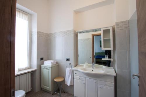 a white bathroom with a sink and a mirror at Palazzo di Primavera Guest House in Caprino Veronese