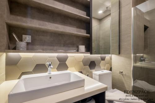 Ceylonz Suites by EdenZpace في كوالالمبور: حمام مع حوض أبيض ومرحاض