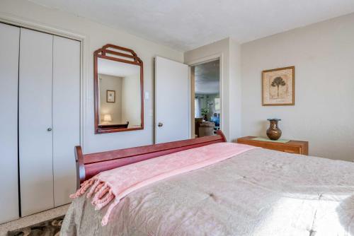 a bedroom with a large bed and a mirror at Shore Delight Waldport Home and Deck, Walk to Beach in Waldport