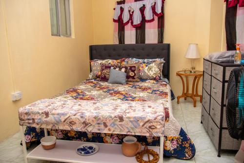 a bedroom with a bed and a table with cups on it at PRI Guest House in Arnos Vale