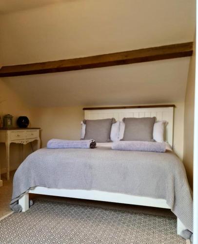 a bedroom with a large white bed with pillows at Newditch Farm - BRS Airport in Bristol