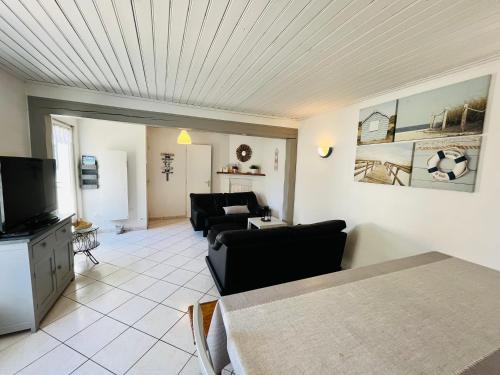 un salon avec un canapé et une télévision dans l'établissement Maison familiale du Devallon, à Saint-Jean-de-Monts