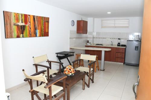a kitchen with a table and chairs in a room at Apartahotel Los Cerezos in Neiva