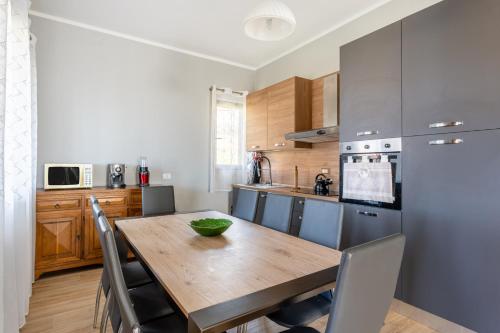 a kitchen with a wooden table and a refrigerator at Casa Vacanze Tuscan Retreat in Macchino