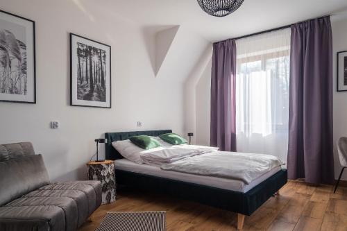a bedroom with a bed and a couch at Ostoja Rakówiec in Dobre