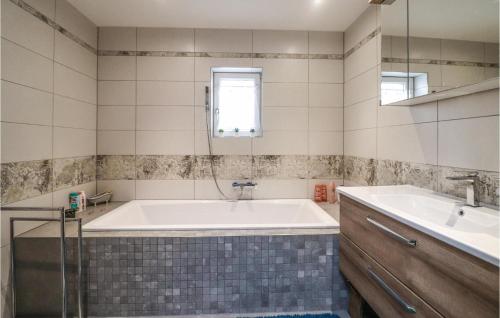 Cozy Home In Bad Ischl With Wifi في باد ايشل: حمام مع حوض كبير ومغسلة