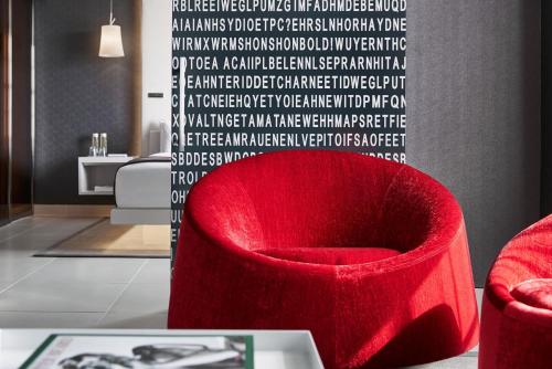 a red chair in a living room with a wall at Hotel Washington in Washington