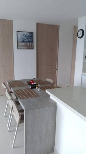a kitchen with a counter and a table and chairs at Hermoso Apartamento Ricaurte Peñazul La Morada. in Ricaurte