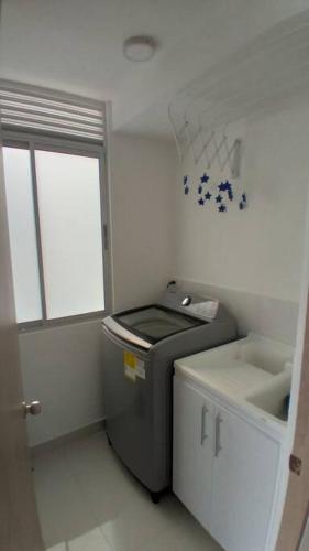 a bathroom with a trash can and a sink at Hermoso Apartamento Ricaurte Peñazul La Morada. in Ricaurte