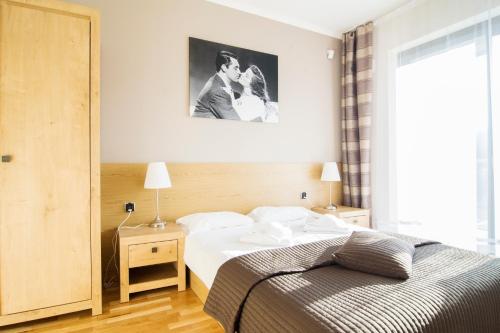 a bedroom with a bed and a picture on the wall at Apartamenty Sun & Snow Tęczowe Wzgórze in Wisła