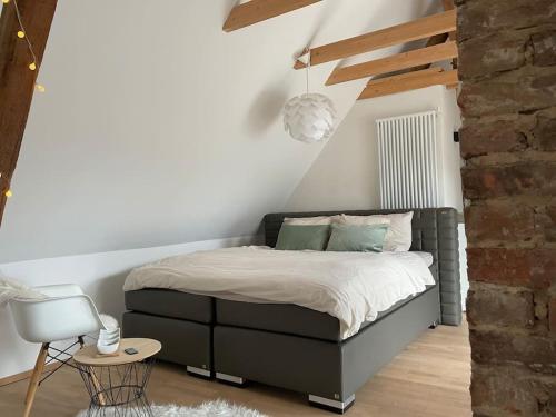 a bedroom with a bed and a brick wall at Häuschen zentral gelegen in Detmold