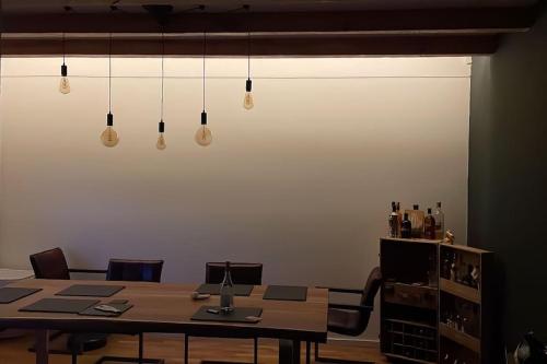 a dining room with a table and chairs and lights at Häuschen zentral gelegen in Detmold