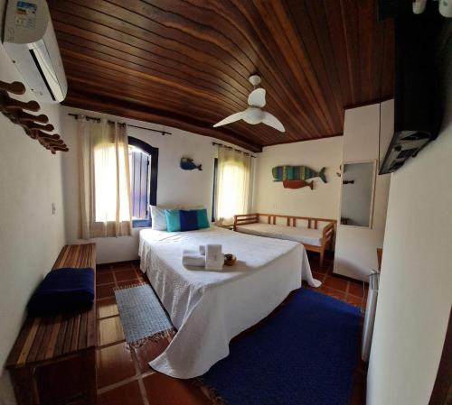 a bedroom with a large bed and a wooden ceiling at Pousada Manga Rosa in Paraty