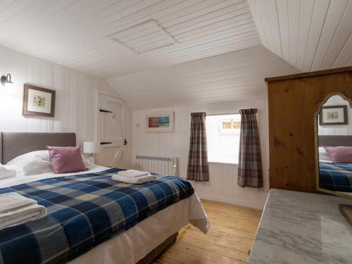 Schlafzimmer mit einem Bett und einem Fenster in der Unterkunft Beaton's Croft House - Uig Skye in Portree