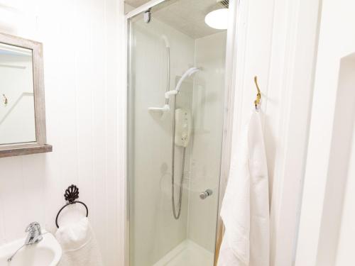ein Bad mit einer Dusche und einem Waschbecken in der Unterkunft Beaton's Croft House - Uig Skye in Portree
