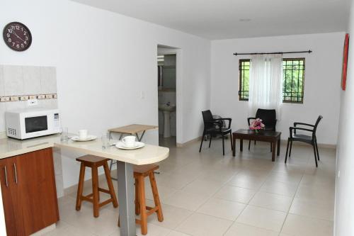 a kitchen and living room with a table and chairs at Apartahotel Los Cerezos in Neiva