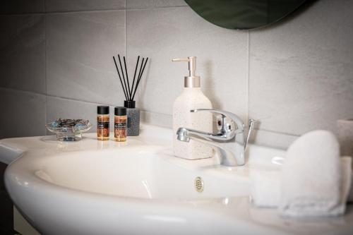 un lavandino in bagno con dispenser di sapone di P&K LUXURY APARTMENTS 2 a Kalamáta