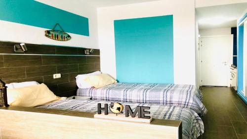 a bedroom with two beds and a sign that says home at Welooveyou Zafiro's in Morro del Jable