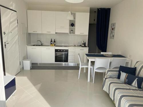 a kitchen and living room with a couch and a table at Bilocale moderno 4 posti vicino al mare in Scarlino