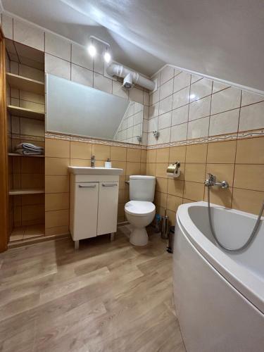 a bathroom with a toilet and a sink and a tub at Apartament Nad Suwalskim Bulwarem in Suwałki