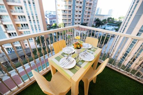 a table and chairs on a balcony with a table and plates at A2J Luxury 1BR Balcony Venice Suite Near Malls in Manila
