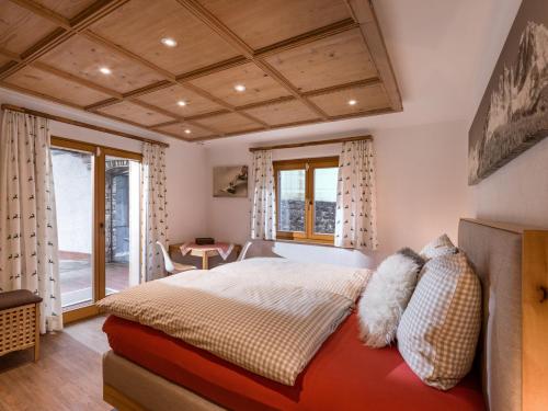 um quarto com uma cama, uma mesa e janelas em Ferienhaus Rauter em Oberndorf in Tirol