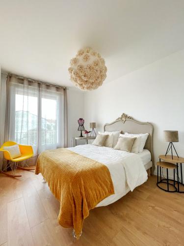 une chambre avec un grand lit et un lustre dans l'établissement VILLA MONT SAINT LOUP '' 5 mn des plages du CAP d'AGDE'', à Agde