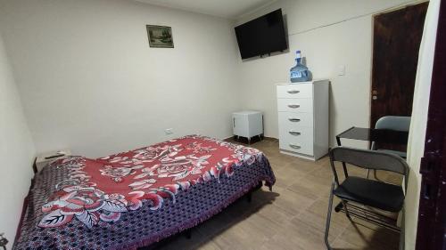 1 dormitorio con cama, silla y vestidor en Habitacion con baño privado en Salta