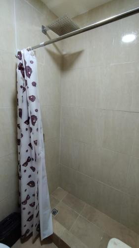 y baño con ducha y cortina de ducha. en Habitacion con baño privado en Salta
