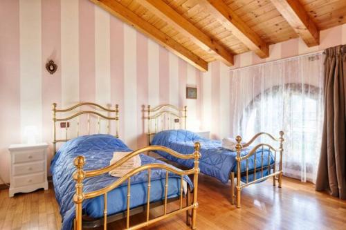 Duas camas num quarto com paredes listradas em Villa Navagero Erizzo - Ca' Rocchetto 2 em Rovarè