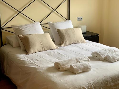 Una cama blanca con dos toallas encima. en VILLA CIUDAD GOLF PLAYA MONTAÑA, en Otura