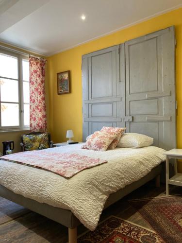 a bedroom with a large bed with yellow walls at au 33 chambres d'hôtes in Saint-Omer