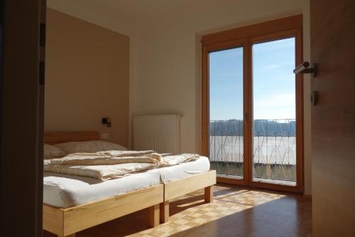 a bedroom with a bed and a large window at Wachahof in Edlitz