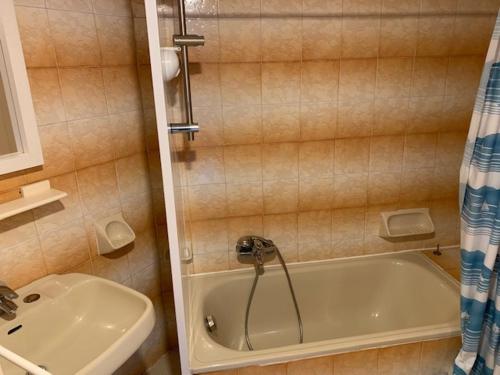 a bathroom with a tub and a sink at Le p'tit coin montagne in Bonneval-sur-Arc