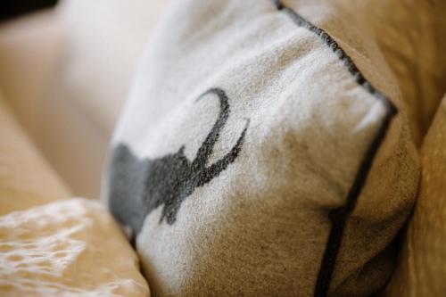 a pillow with a bird on it sitting on a couch at Berghotel Engstligenalp Adelboden in Adelboden