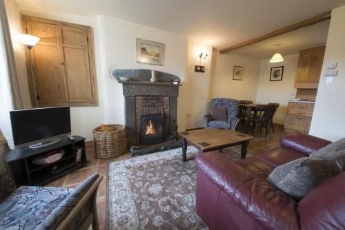 a living room with a couch and a fireplace at Rose Bank Cottage Coniston in Coniston