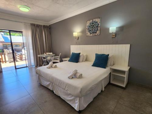 a bedroom with a large white bed with blue pillows at Hippo Lodge Apartments in St Lucia