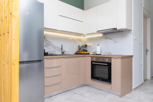 a kitchen with white cabinets and a stove top oven at P&K LUXURY APARTMENTS 1 in Kalamata