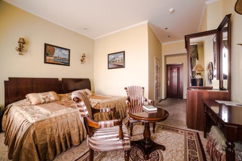 1 dormitorio con 1 cama, mesa y sillas en Меблированные комнаты Ажур Классик, en San Petersburgo