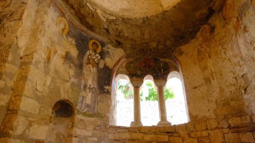 a window in an old stone building with a statue at Likya 202 in Demre