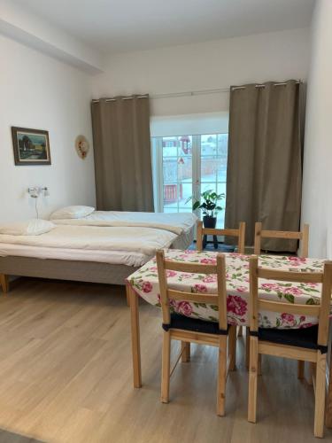 a bedroom with two beds and a table and chairs at Flygeln in Leksand