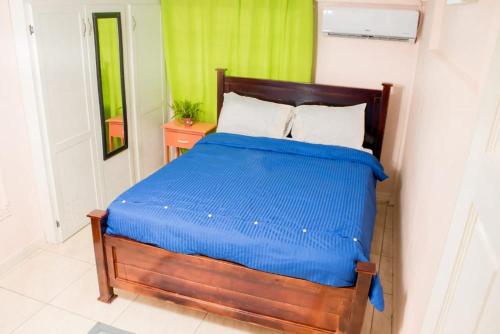 1 dormitorio con 1 cama con edredón azul en Cays Inn Apartments en Ribishi