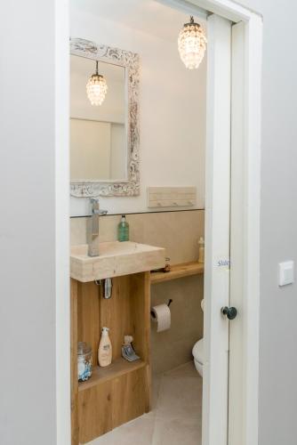 une salle de bain avec un lavabo et un miroir dans l'établissement Maison Amour, à Saint-Marcel