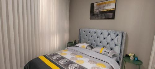 a bedroom with a bed with a gray headboard and pillows at מלון דירות על הים בת ים 39 in Bat Yam