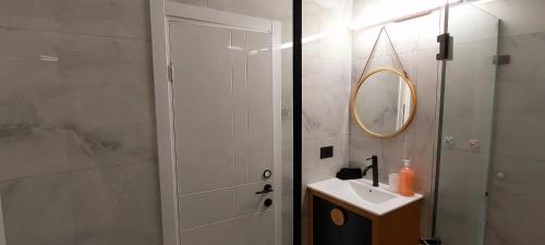 een badkamer met een wastafel, een spiegel en een douche bij מלון דירות על הים בת ים 39 in Bat Yam
