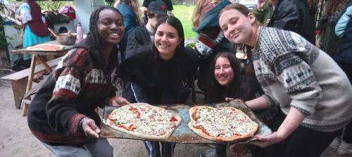 a group of women holding a tray with two pizzas at ECOHUERTO in Ibarra