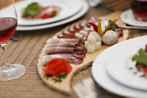 a table with plates of food and a glass of wine at Hotel Termal - Terme 3000 - Sava Hotels & Resorts in Moravske Toplice